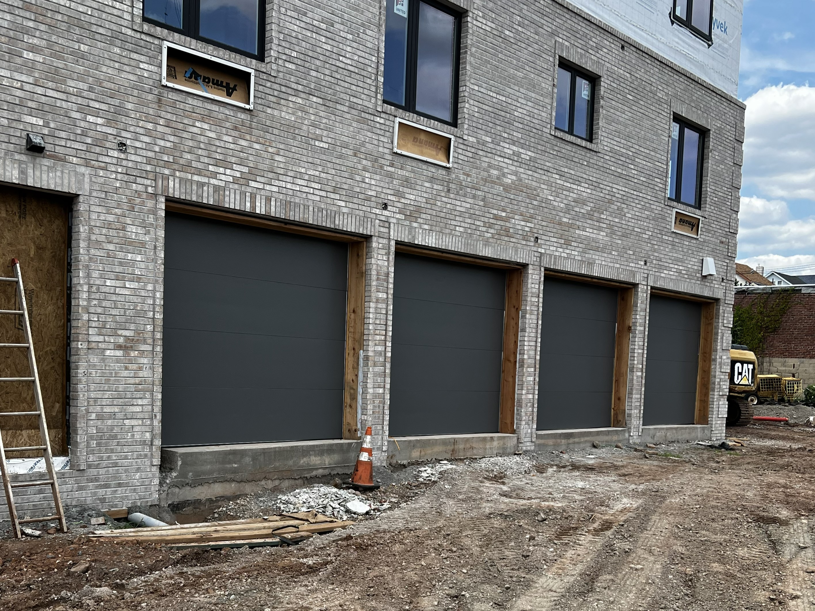 Four gray garage doors installed at apartment complex in Union County New Jersey by Eagle Overhead Door