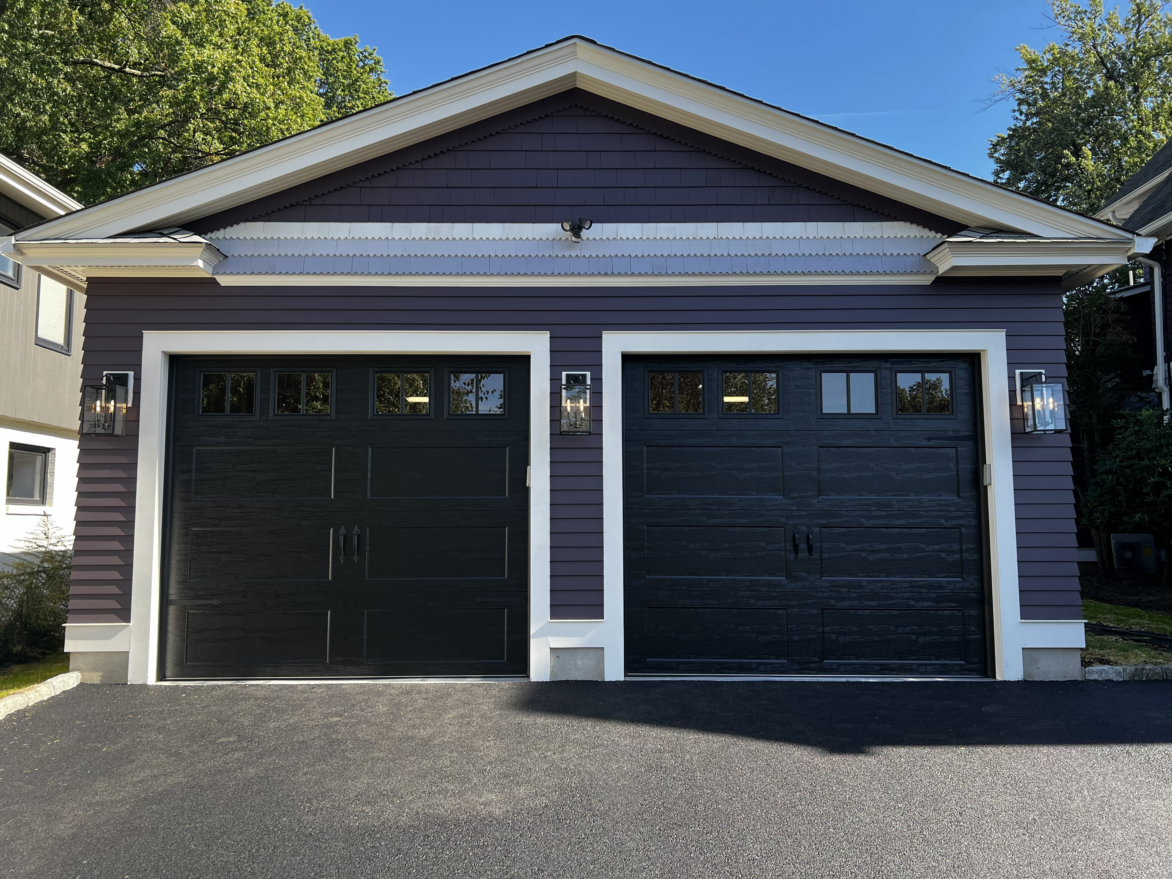 Black garage doors with fresh asphalt driveway installation by Eagle Overhead Door NJ