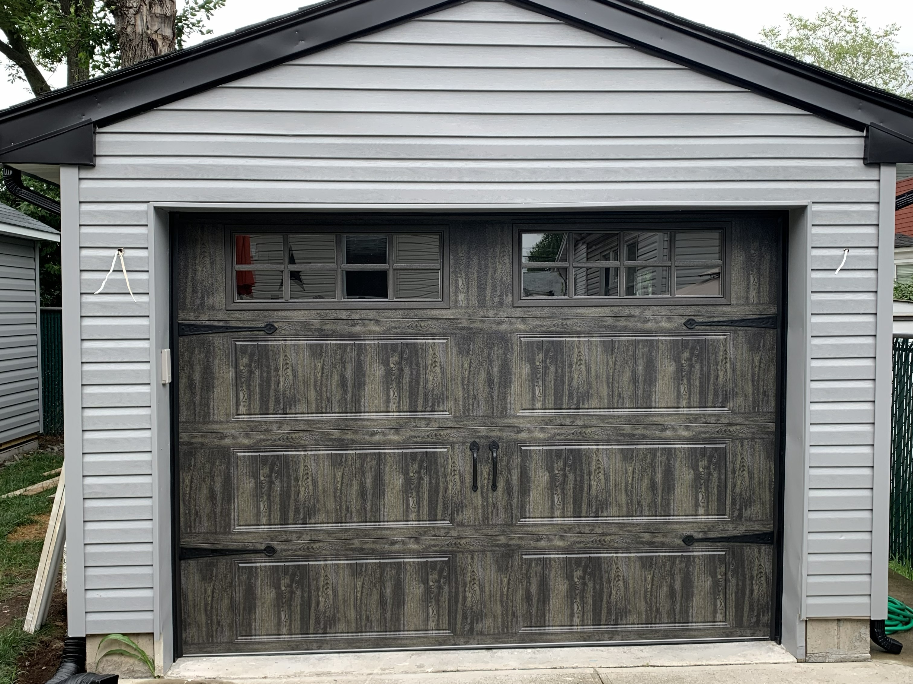 Rustic wood-look garage door on gray detached garage in New Jersey