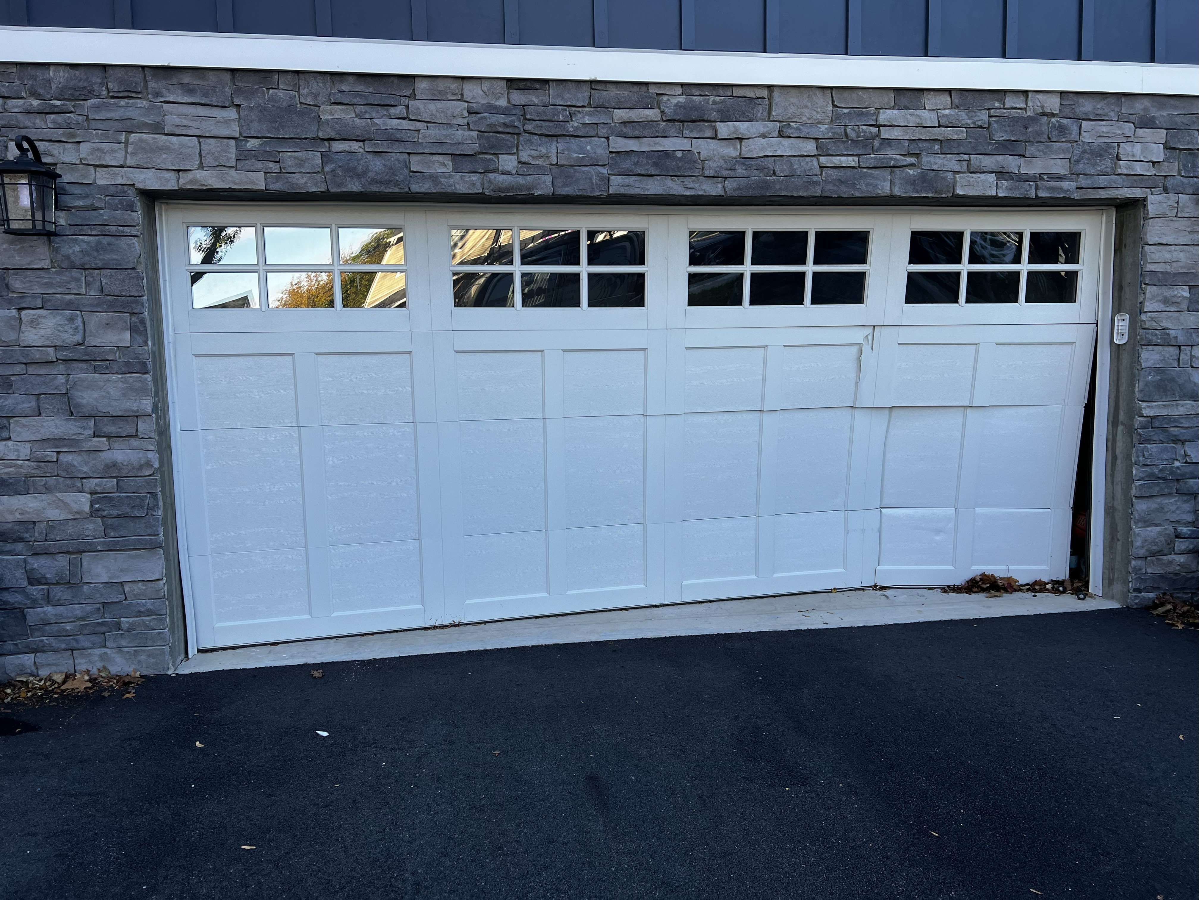 Before: White garage door damaged by vehicle impact - Eagle Overhead Door New Jersey
